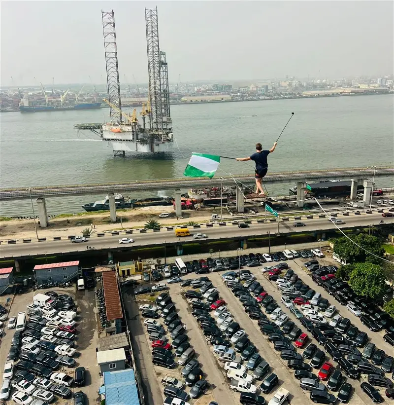 Video: Man captured walking on rope across bridge, train tracks in Lagos